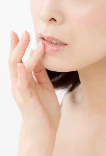 顎をさわる女性の口元